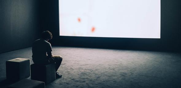 A man sitting in front of a screen