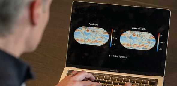 Scientist looking at a computer screen with two weather forecasts